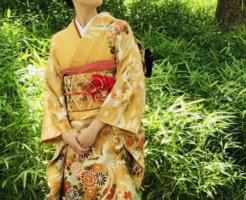 葉っぱの前に立つ着物女性